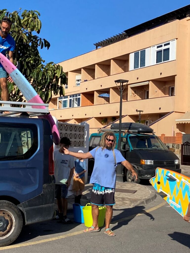 Fuertetribu Surf Para Ninos 39 768x1024 Monitores y niños descargando las tablas de la furgoneta para limpiar todo el material.