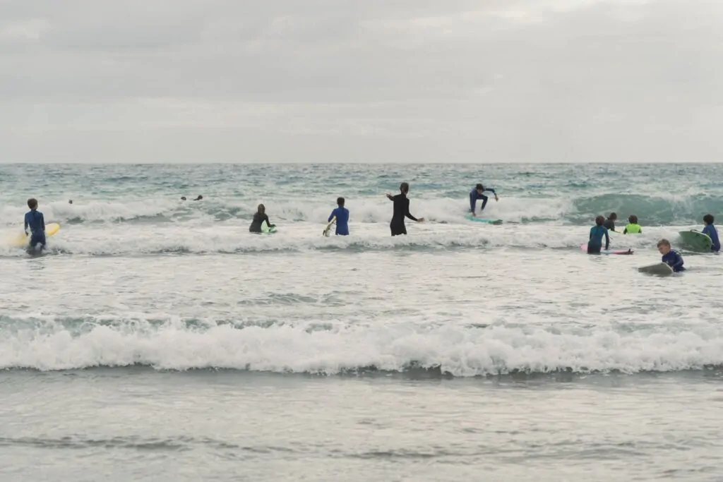 Fuertetribu Surf Para Ninos 34 1024x683 Niños intentando de surfear durante una clase de surf en grupo de niños en Fuerteventura.